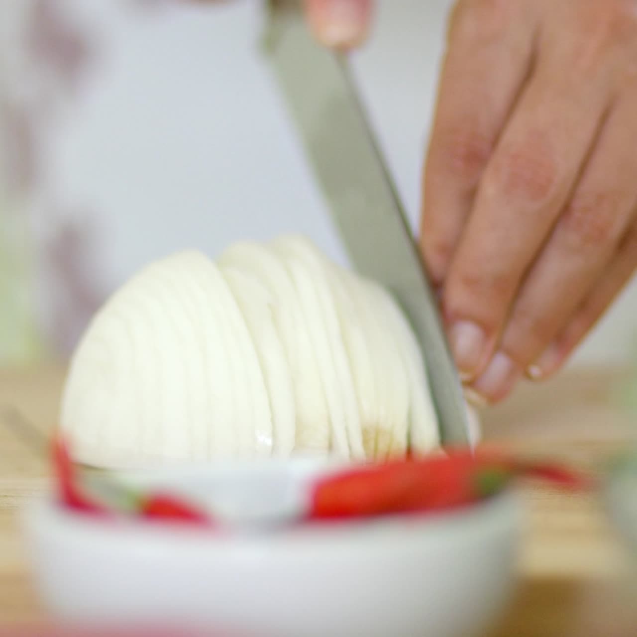 tæt på hænder, der skærer frisk løg