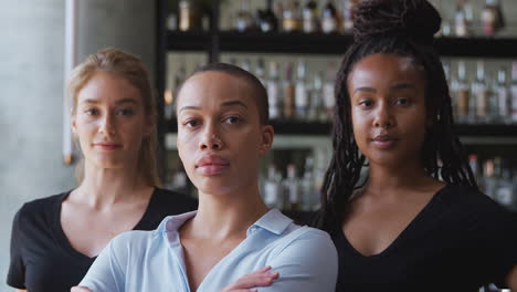 portrait of female owner of restaurant bar with team of female waiting staff standing by counter