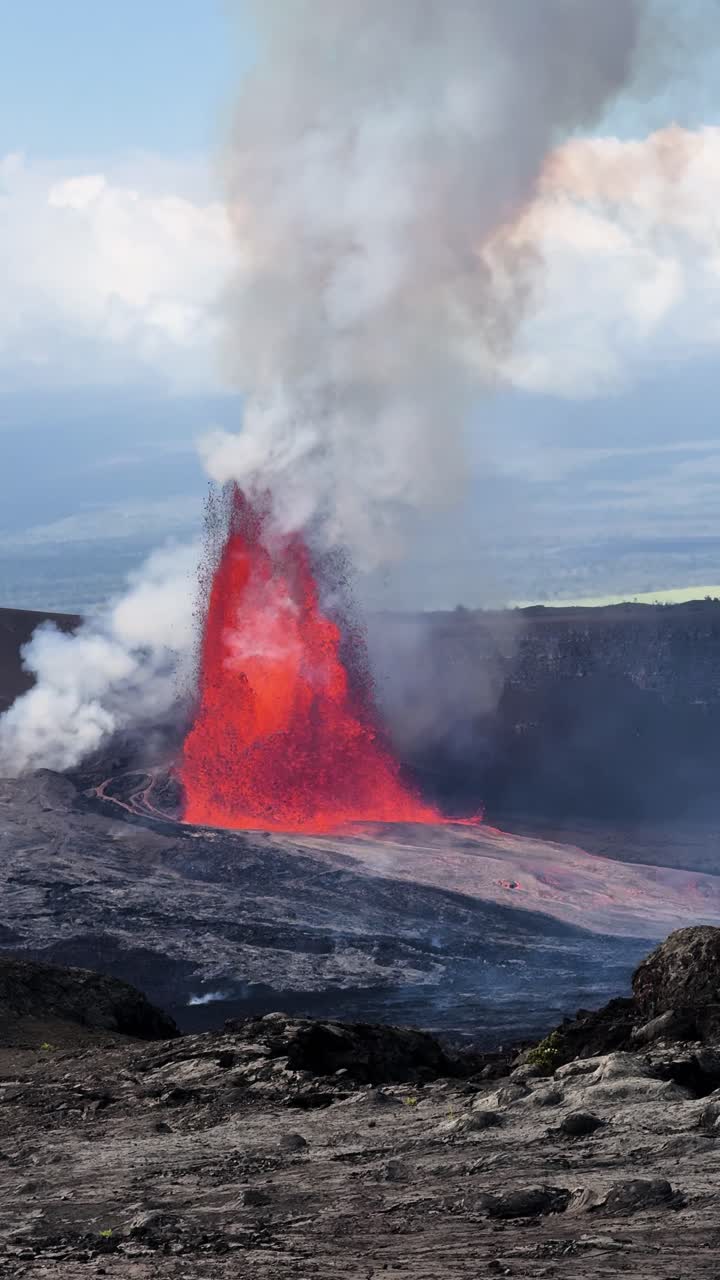 Rekaman vertikal 4K kolom lava dahsyat di Kīlauea, dengan awan abu dan uap padat menjulang di atas kawah serta magma pijar yang menyebar di bawah