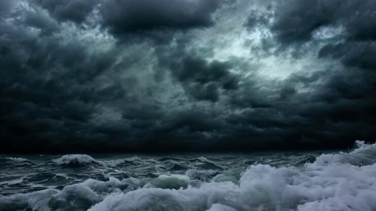 Ripresa drammatica dal basso di onde oceaniche turbolente sotto un cielo tempestoso, catturando la potenza primordiale.