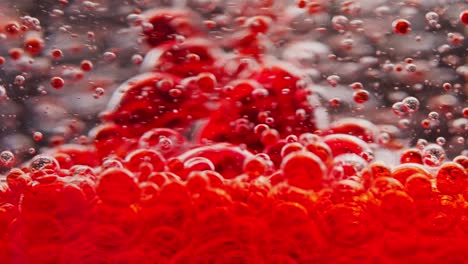 tiro macro de burbujas rojas que se mezclan en agua, flotando alrededor