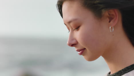 자유를 즐기는 행복한 아시아 여성의 초상화 팔을 들고 해가 지는 해변에서 기 ⁇ 을 느끼고 바람이 불고 있는 머리카락으로 여행욕을 탐구합니다.