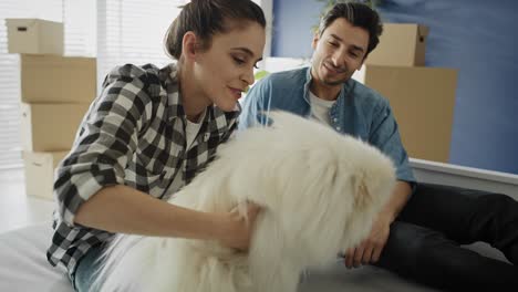 video of couple in new house playing with the dog.