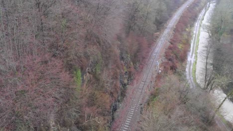 Toma-Aérea-De-Drones-Del-Río-Bocq-Con-Vías-De-Tren-En-El-Bosque-En-La-Provincia-De-Namur,-Bélgica