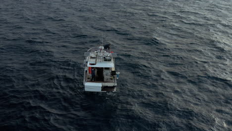 Pescador-Tirando-De-Una-Red-De-Pesca-Con-Capturas-De-Un-Barco-De-Pesca-Anclado-En-Medio-Del-Mar-Adriático