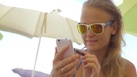 primer plano de una mujer rubia usando un teléfono inteligente
