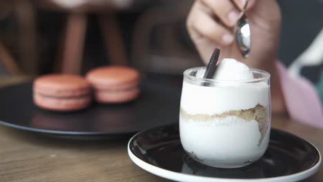 una mujer comiendo postre en un café.