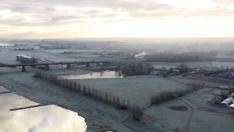 Paisaje-Rural-De-Invierno-Helado-Junto-Al-Río-Sobre-Tierras-De-Cultivo-Holandesas