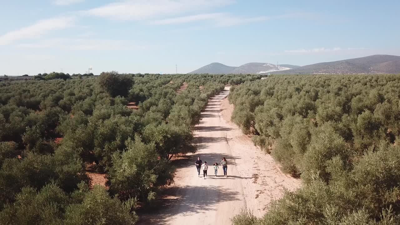 Video of drone flying away from a family running along a path