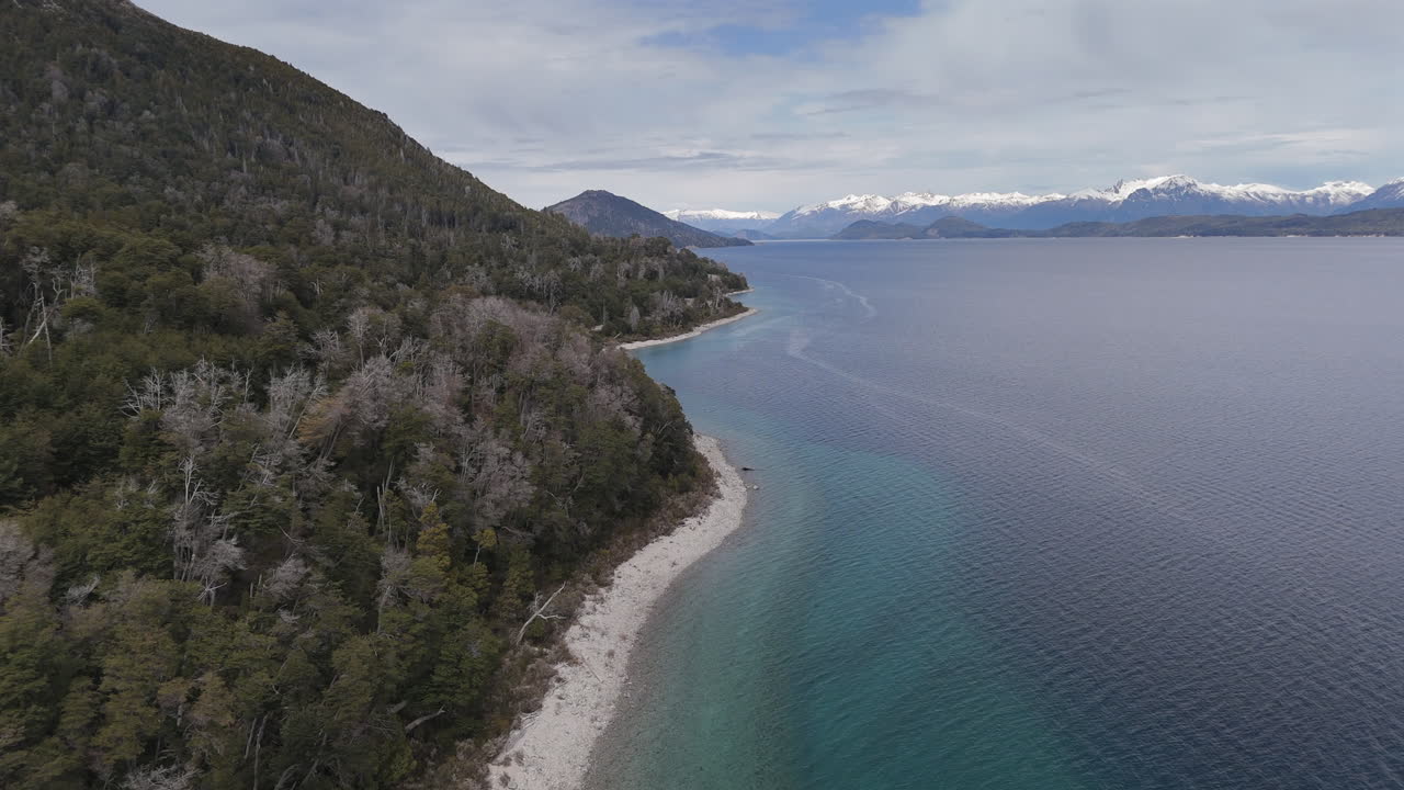 Un vasto panorama aereo del Lago Nahuel Huapi, immerso tra foreste lussureggianti e montagne imponenti, che mostra la bellezza naturale mozzafiato di questo iconico paesaggio argentino