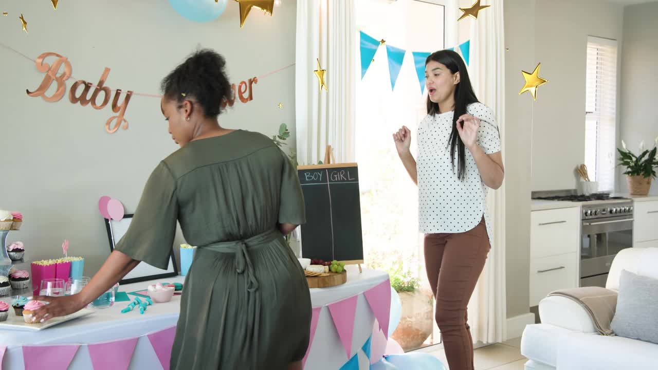 Two hosts preparing baby shower, arranging table, placing cupcakes with confetti overlay over table