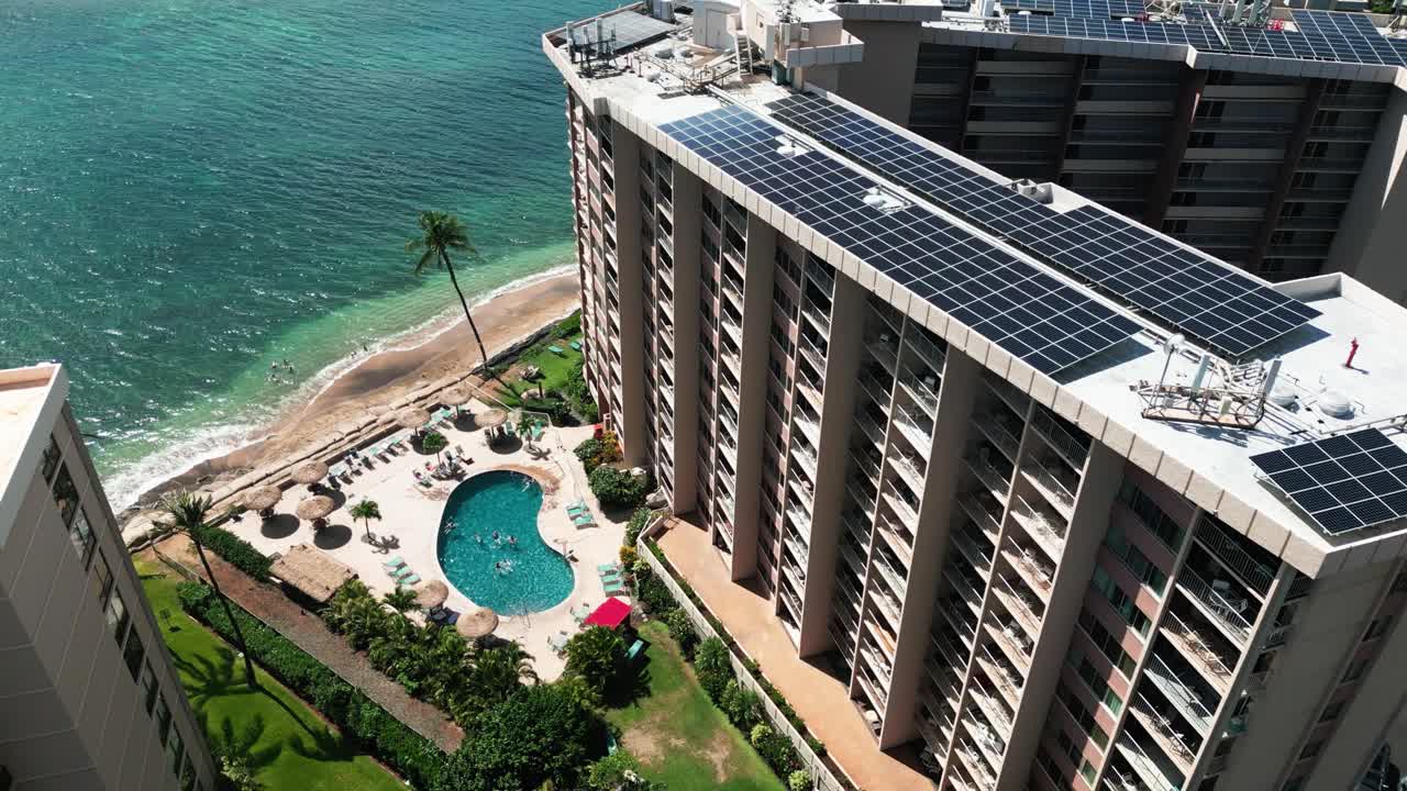 Static Drone Shot of Tropical Island Resort with Solar Panels, Pool, Beach Front, Ocean, Palm Tree