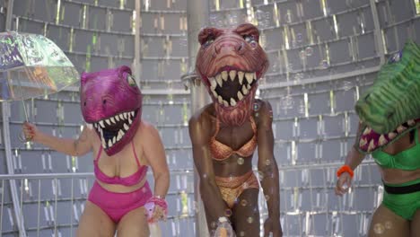 artistas con disfraces de cabeza de dinosaurio actuando y bailando