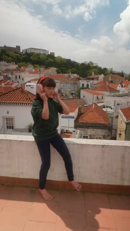 girl with headphones on a rooftop enjoying the city view