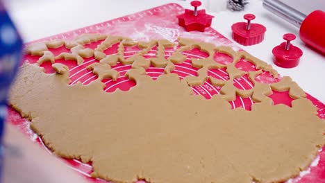 cutting out gingerbread cookies from raw flattened dough