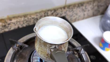 bubbling milk in a rustic pot over a gas flame—great for cooking, cultural, or morning routine content