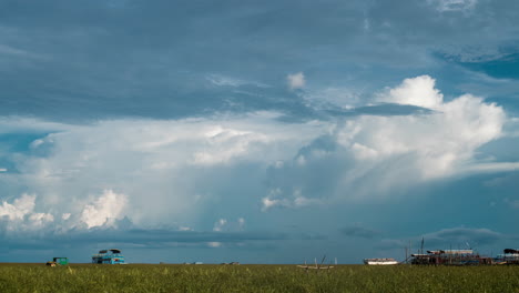 cloud formations over boars and village nested on the banks of the tonle sap lake, cambodia