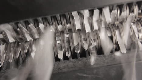 shredder cutting paper from below, pan left to right