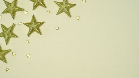 christmas stop motion. glitter gold stars on left corner of beige background