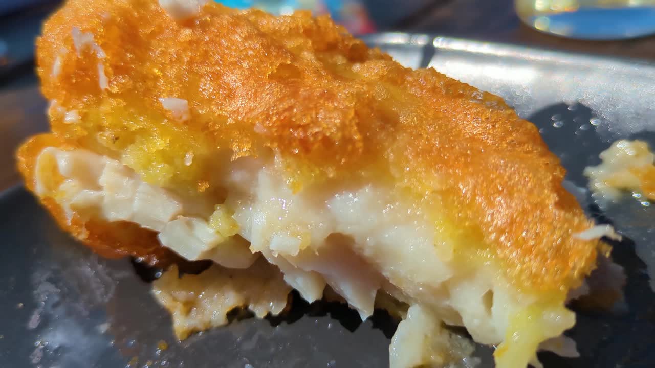 Crispy Battered Classic British Cod Fish in Natural Sunlight. Traditional Fast Food Cuisine.