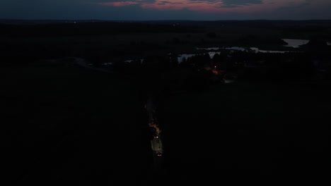 aerial view following a camper van on a countryside road, dark evening