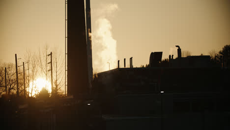 chemical factory silhouette emitting toxic smoke pollution during sunset