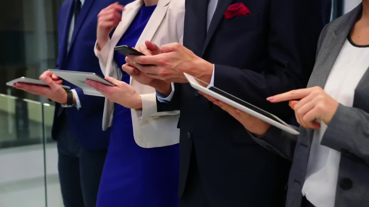 사무실에서 휴대 전화와 디지털 태블릿을 사용하는 비즈니스 임원