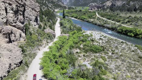 aerial tracking of two cars while unveiling the river and the road to traful, patagonia argentina