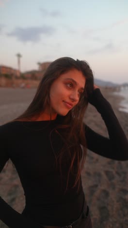 молодая женщина на пляже во время захода солнца