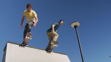 dos amigos hombres patinando juntos en un día soleado