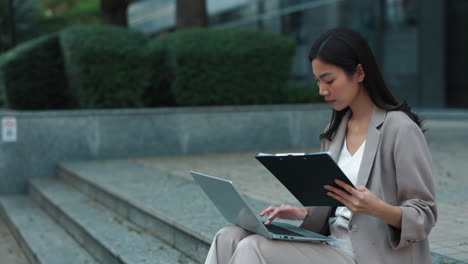 mujer de negocios trabajando en una computadora portátil al aire libre