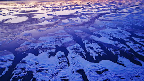 Drone's-perspective-as-it-reveals-the-grandeur-of-ice-masses-on-the-water-during-a-cold-sunrise