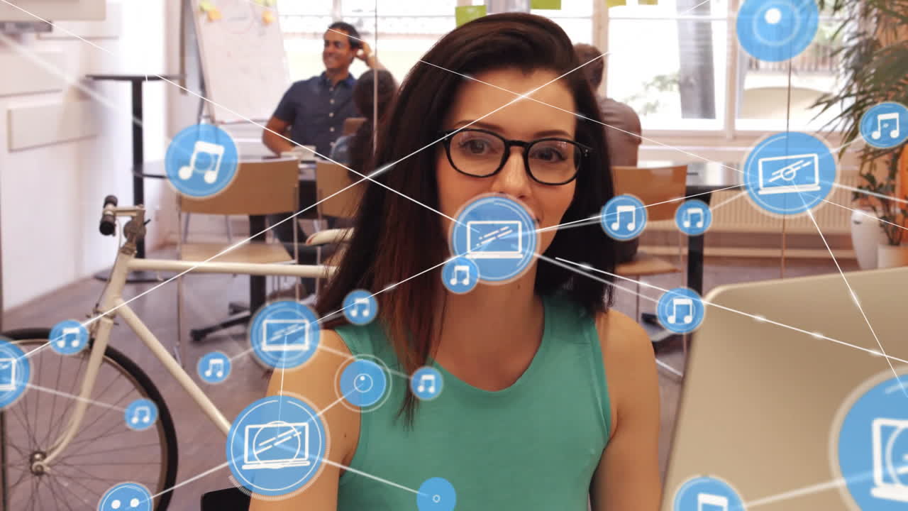 animación de iconos de los medios sobre una mujer de negocios biracial usando una computadora portátil