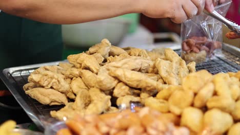 worker bagging fried snacks on a production line