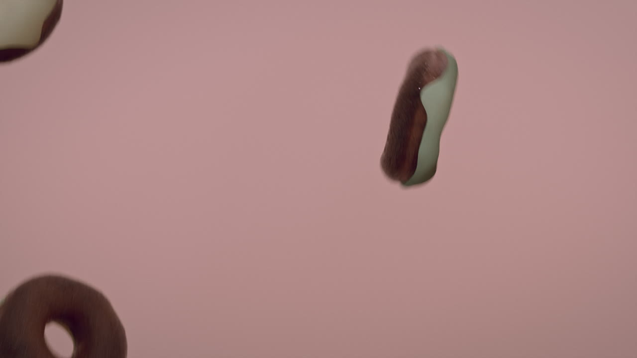 White glaze donuts on a light pink background