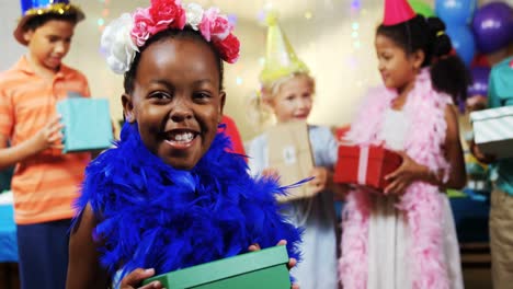 Girl-holding-a-gift-box-during-birthday-party-at-home-4k