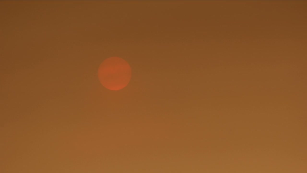 Timelapse van zonsondergang achter rokerige luchten