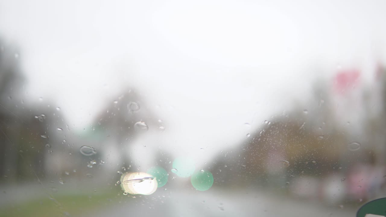 Blurry windshield whiper during heavy rain from inside a car. Car driving on a rainy day