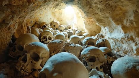 a large group of skulls in a cave filled with rocks