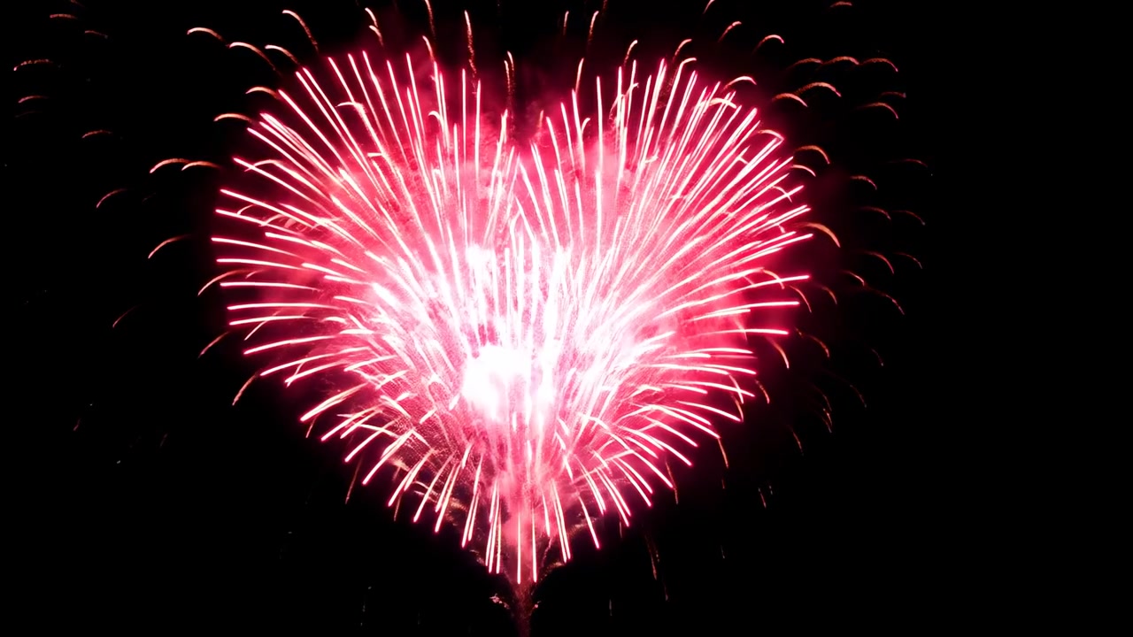 Spettacolo di fuochi d'artificio rossi a forma di cuore nel cielo notturno