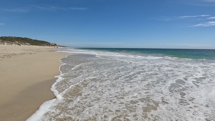 Aufnahme aus niedriger Perspektive von Wellen, die am Mindarie Beach, Perth, Australien, brechen