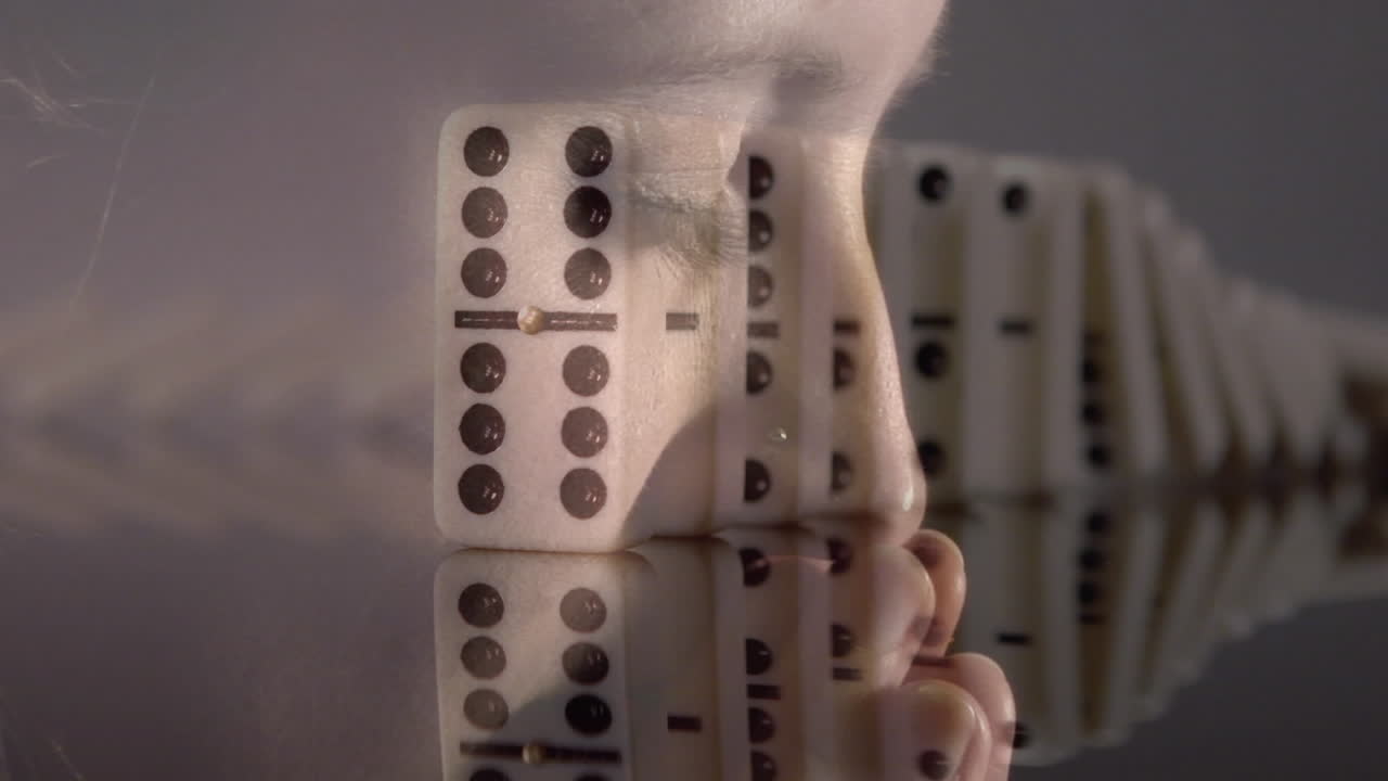 카우카스 여성이 기도하는 클로즈업에 대항하여 도미노가 떨어지는 복합 비디오