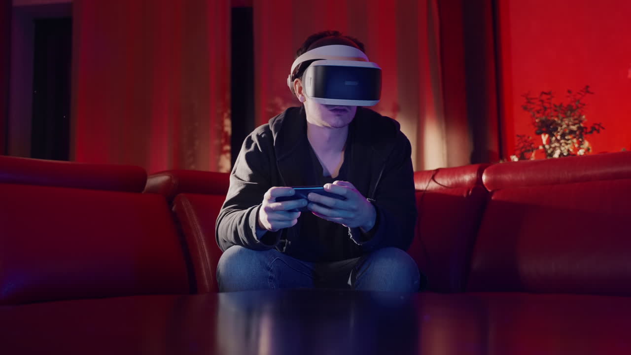 Persona con visore VR che gioca a un gioco mobile su un divano