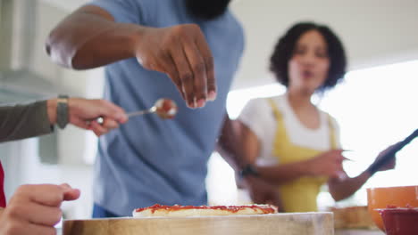 Diverse-male-and-female-friends-cooking-in-kitchen-in-slow-motion