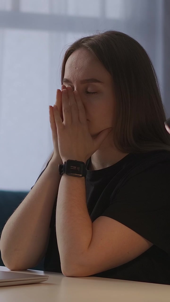 Giovane donna stressata e sopraffatta mentre lavora al portatile