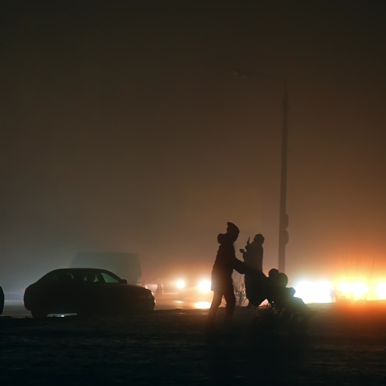 Ukrainians walking by the dark streets at night during the time of blackout. Foggy cold winter night in the city with no electricity