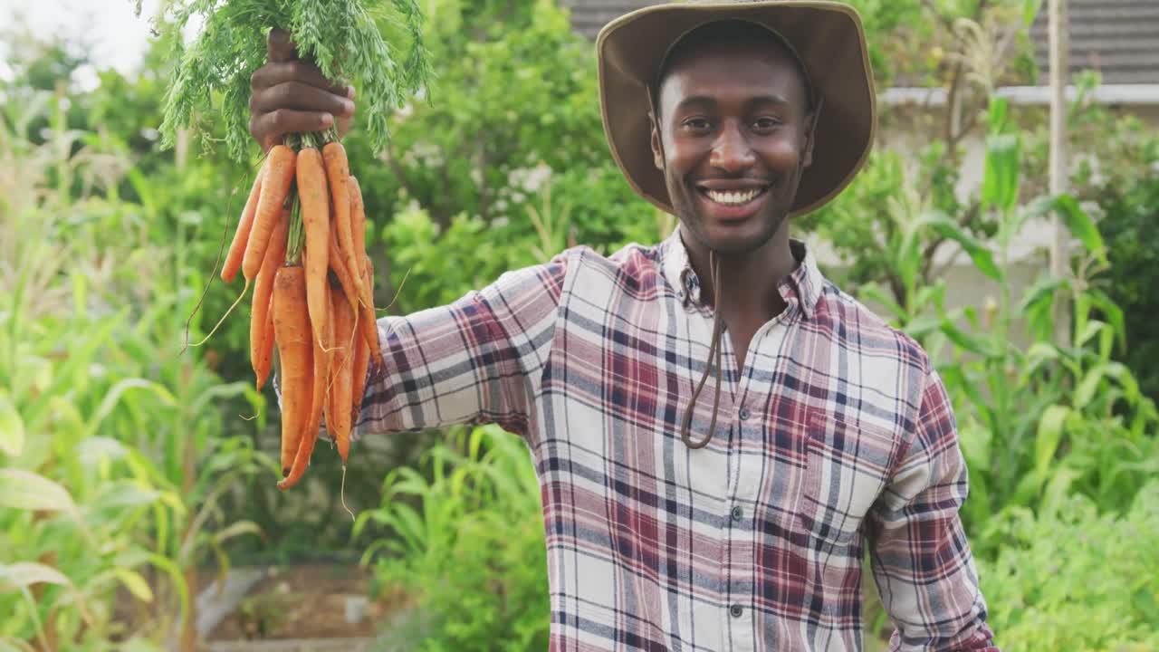 hombre afroamericano mostrando zanahorias a la cámara