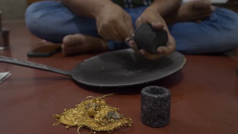 focus sélectif d'un orfèvre indien se préparant à fondre des bijoux en or dans un atelier