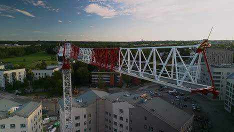 Energetic-angle-of-a-flat-top-construction-crane's-working-jib,-sky-and-forest-in-the-background