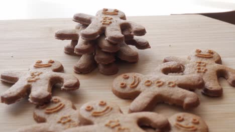 zoom out view of gingerbread men stacked and scattered on the table.